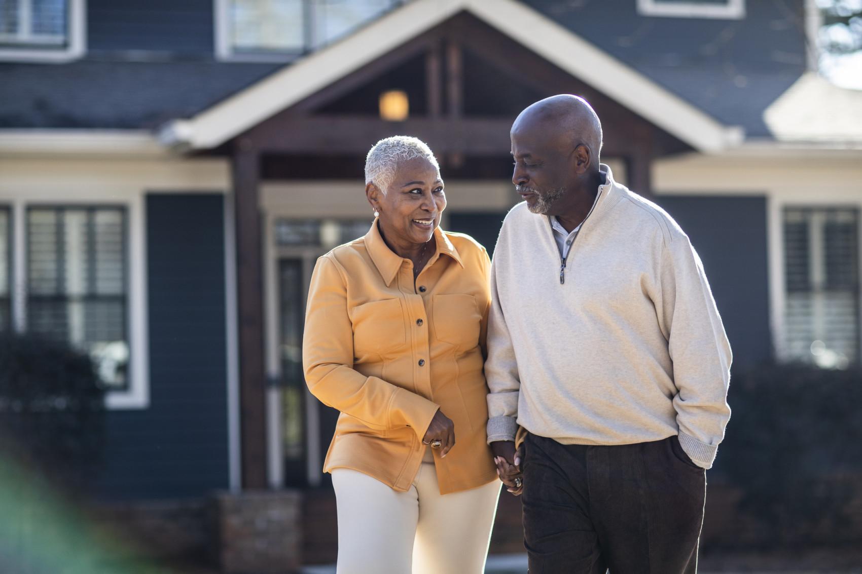 Couple Walking in front of house.