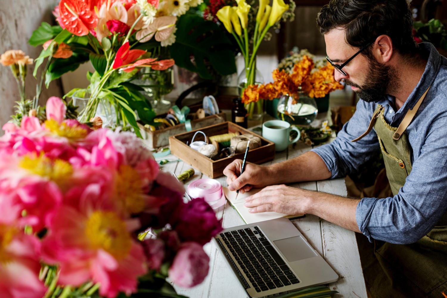 Man on laptop in flower shop